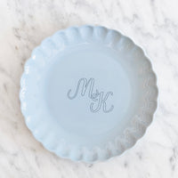 Lichtblauw bord met feestelijke rand en gepersonaliseerd met een monogram