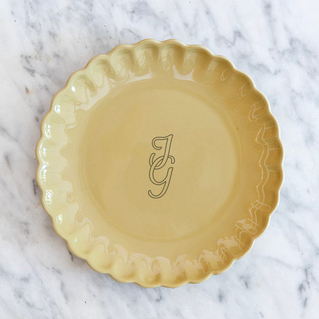 Okergeel bord met een feestelijke rand en gepersonaliseerd met een monogram