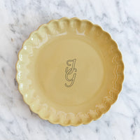 Okergeel bord met een feestelijke rand en gepersonaliseerd met een monogram