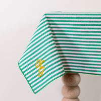 Frisgroen en poederroze gestreept tafelkleed, gepersonaliseerd met een monogram in gouddraad