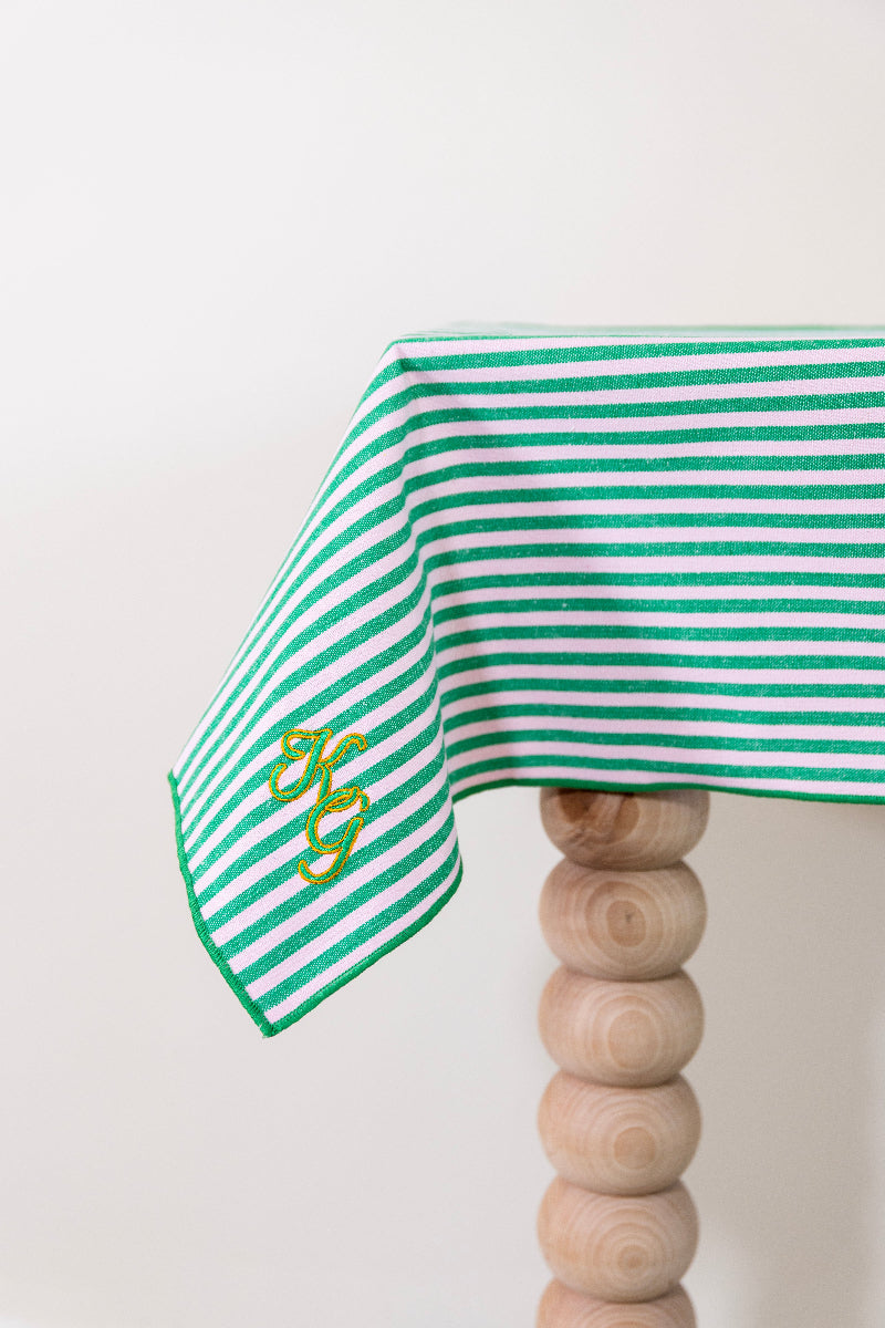 Frisgroen en poederroze gestreept tafelkleed, gepersonaliseerd met een monogram in groen en gouddraad