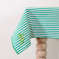 Frisgroen en poederroze gestreept tafelkleed, gepersonaliseerd met een monogram in groen en gouddraad