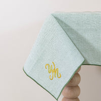 Olijfgroen tafelkleed gepersonaliseerd met een monogram in groen en gouddraad