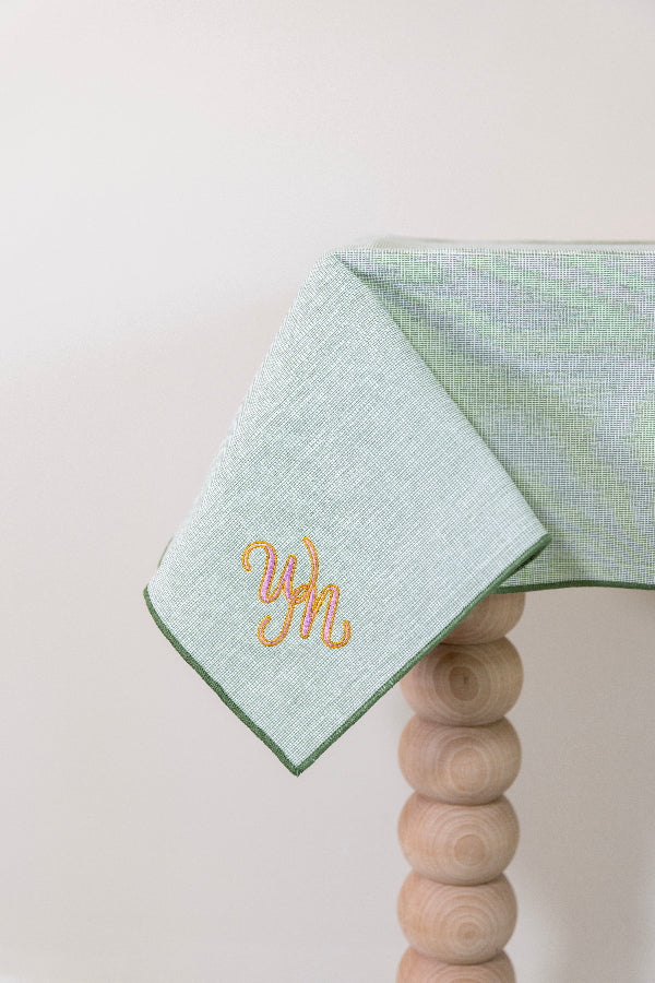 Olijfgroen tafelkleed gepersonaliseerd met een monogram in roze en gouddraad