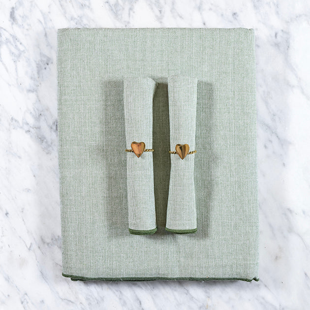 Olijfgroen tafelkleed gecombineerd met een twee bijpassende olijfgroene servetten en servetringen