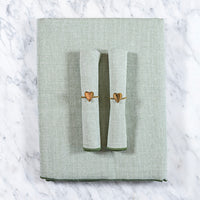 Olijfgroen tafelkleed gecombineerd met een twee bijpassende olijfgroene servetten en servetringen