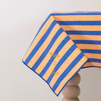 Oranje-blauw gestreept tafelkleed met de namen van het liefdeskoppel erin geborduurd met gouddraad