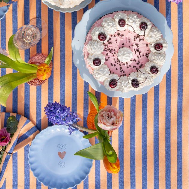 Oranje en blauw gestreept tafelkleed voor een feestelijk gedekte tafel