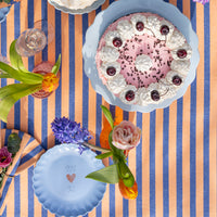 Oranje en blauw gestreept tafelkleed voor een feestelijk gedekte tafel