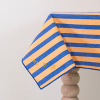 Oranje-blauw gestreept tafellaken met de initialen geborduurd in de stof 