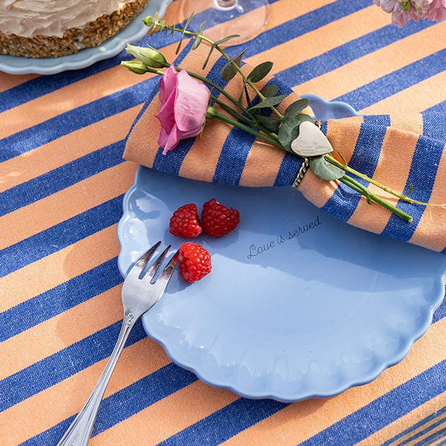 Oranje-blauw gestreept tafelkleed met een bijpassende servet voor een zomerse en feestelijk gedekte tafel
