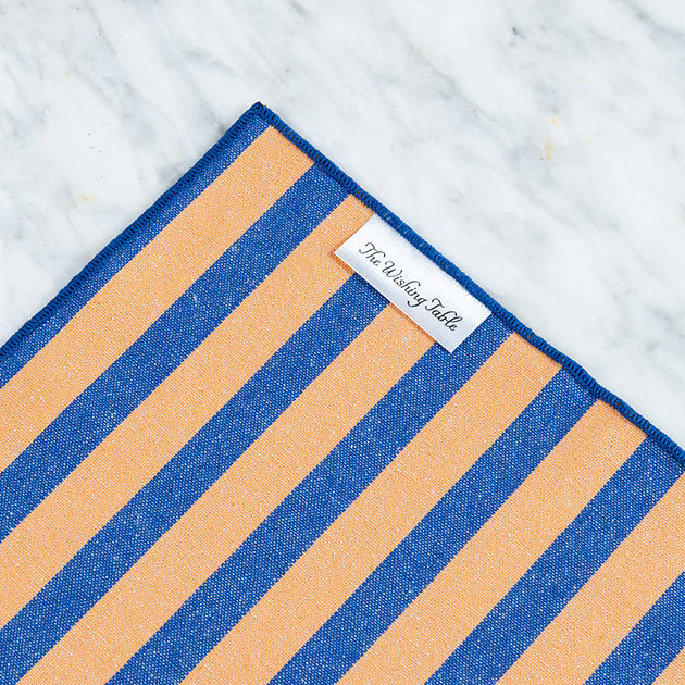Abrikoos-kobalt tafelkleed met een label van The Wishing Table