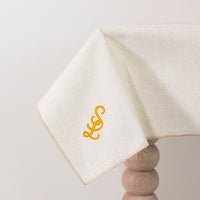 zachtbeige tafelkleed gepersonaliseerd met een monogram in gouddraad
