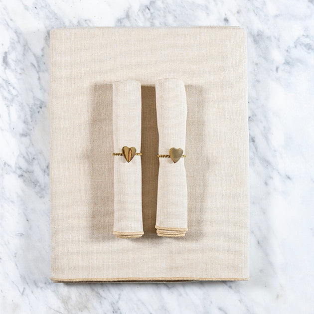 Zachtbeige tafelkleed gecombineerd met een twee bijpassende zachtbeige servetten en servetringen