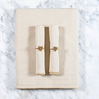 Zachtbeige tafelkleed gecombineerd met een twee bijpassende zachtbeige servetten en servetringen